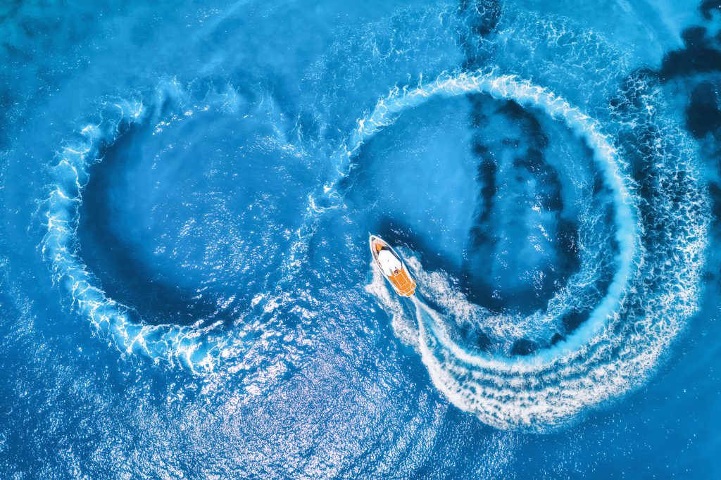 A areal view of a boat making circles on the sea to show the circular impact