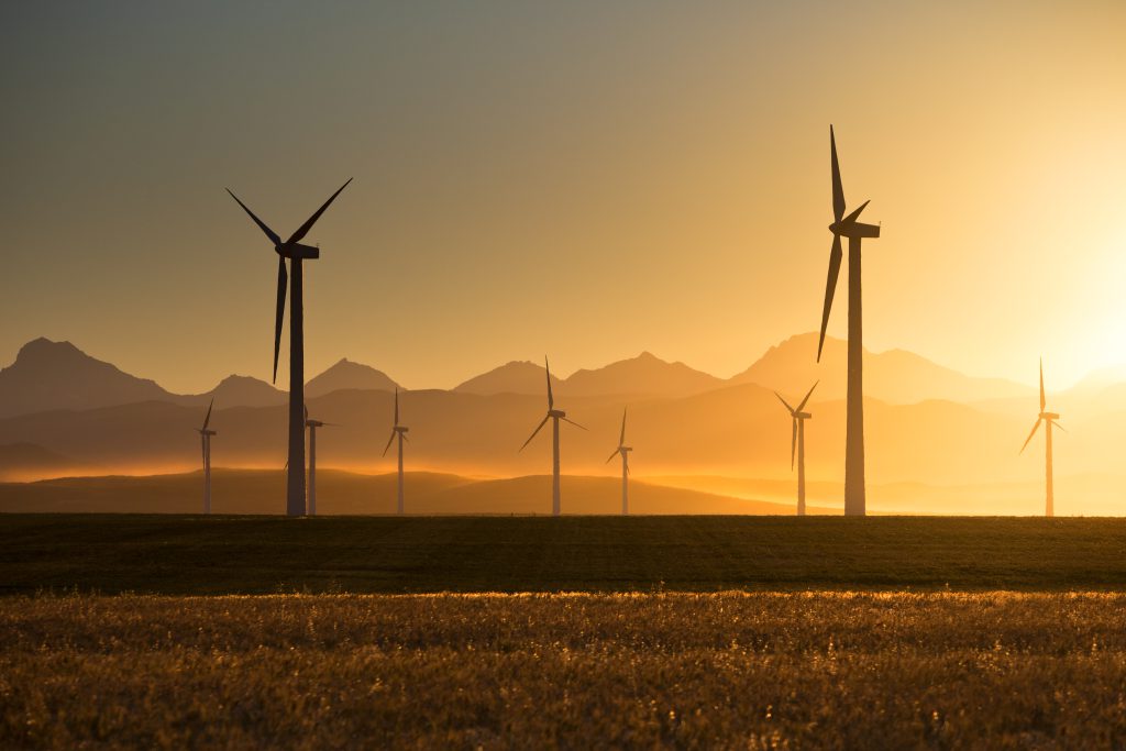 A row of modern wind turbines during a brilliant sunset.