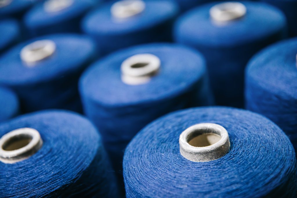 A close zoom of cones of blue spun yarn.