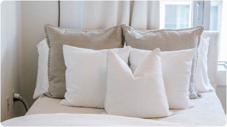 Pillows in a bed showing the home textile application of NOOSA™'s bio-based and recyclable fiber.