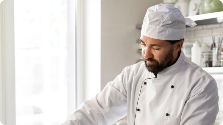 A cook wearing an apron showing the jobwear application of NOOSA™'s bio-based and recyclable fiber.