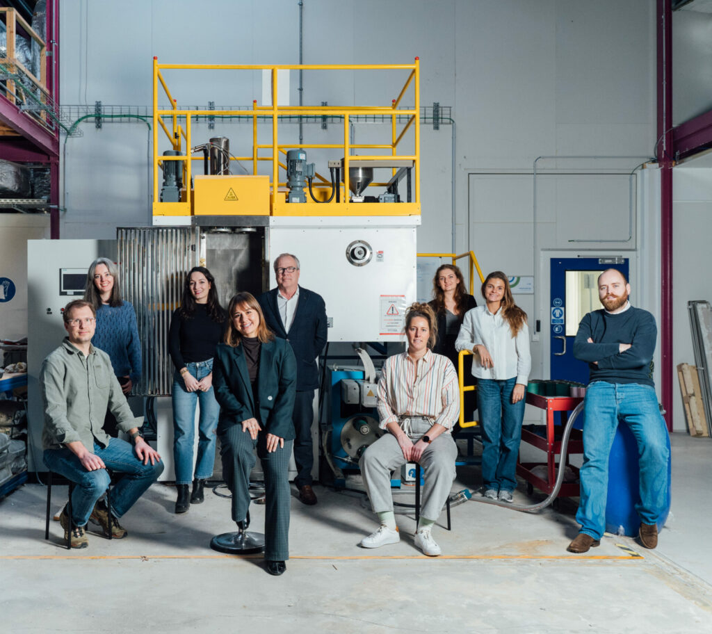 The NOOSA® team is facing a PLA filament extrusion line in a factory material science experts and textile engineers designers